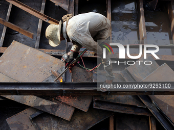 A worker works at a ship demolition site near Dala jetty in Yangon, Myanmar on December 7, 2022. (