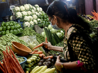 A customer buys vegetables in a vegetable market place in Mumbai, India, 09 December, 2022. Inflation in India likely softened to a nine-mon...
