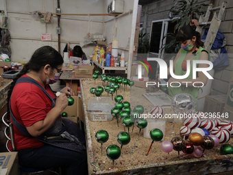 Josefina Aguilar, industrial biochemist; and employees, during the painting and decoration of handmade blown glass Christmas spheres in Tlah...