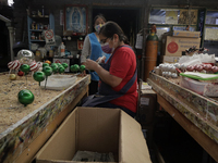 Josefina Aguilar, industrial biochemist; and employees, during the painting and decoration of handmade blown glass Christmas spheres in Tlah...