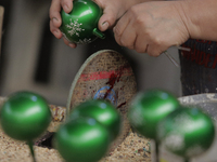 Die-cutting of handmade blown glass Christmas spheres in a workshop located in Tlahuac, Mexico City. (