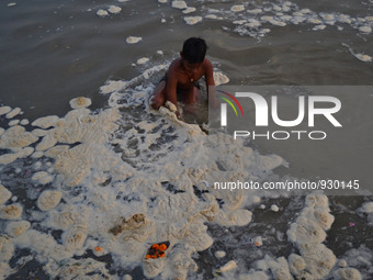 Am indian boy search for coins which devotees offer during worship, in polluted water of River Ganges,in Allahabad on November 27,2015.Over...