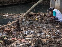 A man fishing at a river covered by garbage in Bogor, West Java, Indonesia, on Wednesday, December 17, 2022. The Earth is literally covered...