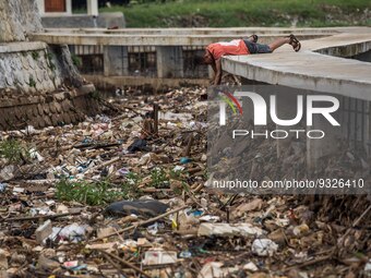 Indonesian environmental activist, Suparno Jumar takes a picture of plastic pollution at the river in Bogor, West Java, Indonesia, on Wednes...
