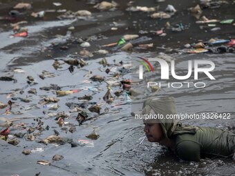 A man working at a polluted canal in Bogor, West Java, Indonesia, on Wednesday, December 17, 2022. The Earth is literally covered in water,...