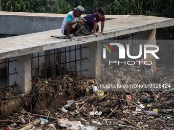 A man fishing at a river covered by garbage in Bogor, West Java, Indonesia, on Wednesday, December 17, 2022. The Earth is literally covered...
