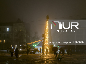 A municipal worker decorates a Christmas tree at the Sofiyska square during power outage after a massive Russian missile attack on Ukrainian...