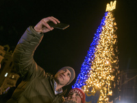 People take photos with the mayor of Kyiv Vitaliy Klichko near the Christmas tree at the Sofiyska Square after a massive russian drones atta...