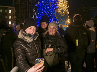 People take photos the Christmas tree at the Sofiyska Square after a massive russian drones attack on Ukrainian power infrastructure early m...