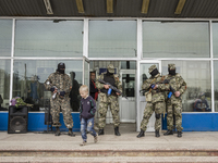 Pro-Russian armed men in military fatigues stand guard outside a regional administration building seized in the night by pro-Russian separat...