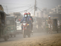 People make their move in a dusty road in Dhaka, Bangladesh on December 20, 2022.  (