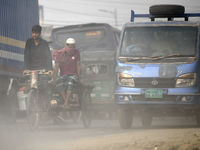 People make their move in a dusty road in Dhaka, Bangladesh on December 20, 2022.  (