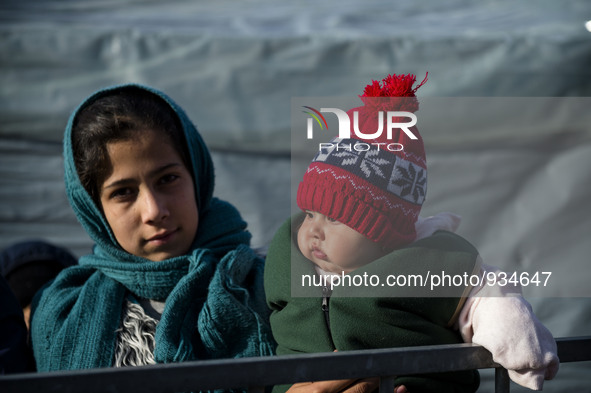 A Syrian mother, along with her baby eight months ago the row to take winter clothes, provided by volunteers from the refugee camp in Sentil...