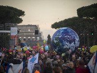 People play with a giant balloon representing Earth at Piazza Venezia during a rally calling for action on climate change on November 29, 20...