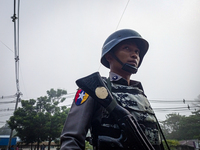 An armed policeman stands guard at the roadside during the visit of the Myanmar junta leader Min Aung Hlaing to Thanlyin township, on the ou...
