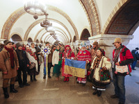 Ukrainians wearing national ethnic clothes sing Christmas carols and collect money for the Ukrainian army at a metro station in Kyiv, Ukrain...