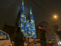 People look at the St. Nicholas Catholic Church church illuminated by the world-famous Swiss light artist Gerry Hofstetter Before Christmas...