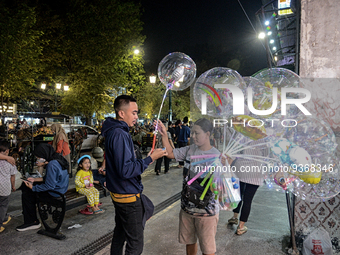 A man buys a ballons from a street vendor at Malioboro Street during holiday for the end of the year in Yogyakarta, Indonesia on December 30...