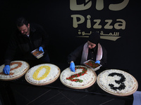 Palestinians make big pizza shows the new year 2023 in a fast-food restaurant in Gaza city, onDecember 31, 2022. (