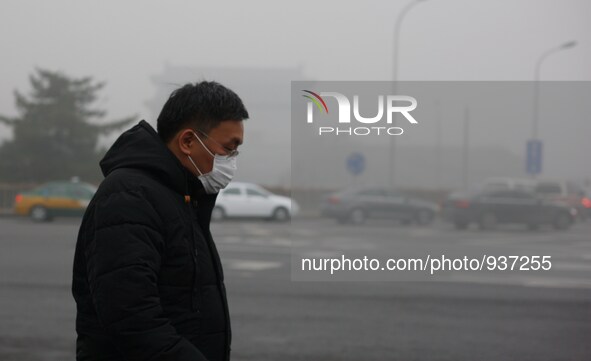 (151201) -- BEIJING, Dec. 1, 2015 () -- A man wearing respirators walk on the street in Beijing, capital of China, Dec. 1, 2015. Heavy fog h...