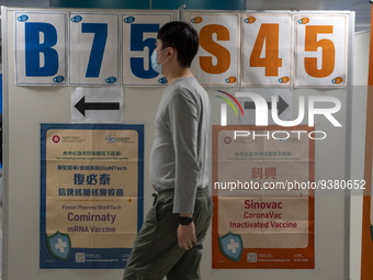 A man walks pass a sign for the Sinovac CoronaVac Inactivated Vaccine by China Biotechnology company, Sinovac Biotech Ltd. and a sign for th...