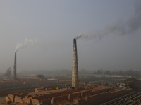 Smoke come out from kilns at brickfields in Munshiganj, Bangladesh on January 3, 2023. (