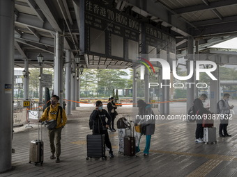 Travelers from China wearing face mask with luggages arrived in Shenzhen Bay Port on January 4, 2023 in Hong Kong, China. According to Local...