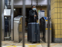 A man with a suitcase passing trough a gate to enter an MTR train platform for a train bound for Lok Ma Chau Control Point on January 8, 202...