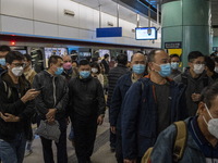 Travelers wearing face masks arriving at Lok Ma Chau MTR Station on January 8, 2023 in Hong Kong, China. Hong Kong today resumes quarantine...