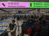 Travelers wearing face mask waiting in line to cross the border at the Lok Ma Chau Border Crossing on January 8, 2023 in Hong Kong, China. H...