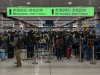 Travelers wearing face mask waiting in line to cross the border at the Lok Ma Chau Border Crossing on January 8, 2023 in Hong Kong, China. H...