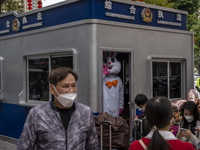 A worker dress in a rabbit costume standing inside a police post outside Futian Port on January 8, 2023 in Shenzhen, China. Hong Kong today...