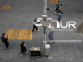 People walking pass security cameras on January 8, 2023 in Shenzhen, China. China today lifts its requirement for inbound travelers to under...