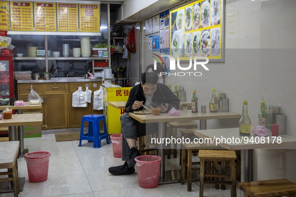 A man eating inside a restaurant on January 8, 2023 in Shenzhen, China. China today lifts its requirement for inbound travelers to undergo a...