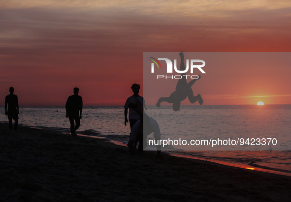 A Palestinian youth practice his parkour skills on Gaza Beach during sunset, on January 11, 2023.  