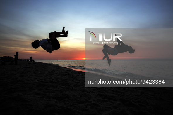 Palestinian youths jump in front of Gaza Beach and practice Parkour skills during sunset, , on January 11, 2023.  