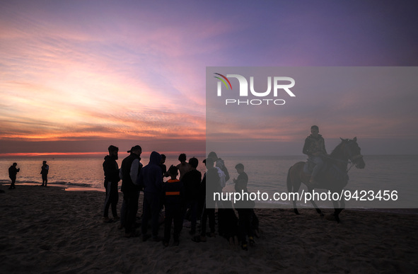 Palestinians youths enjoy in front of Gaza Beach during sunset, on January 11, 2023.  