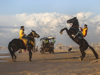 Palestinian youths on their horses take during sunset on the Gaza beach, on January 12, 2023.  (