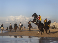 Palestinian youths on their horses take during sunset on the Gaza beach, on January 12, 2023.  (