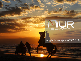 A Palestinian youth on his horse take during sunset on the Gaza beach, on January 12, 2023.  (