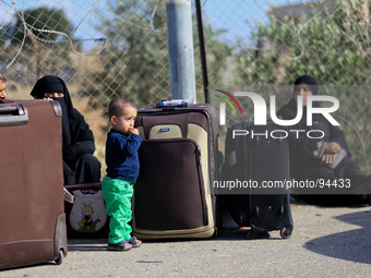 A Palestinian boy stands next to his family luggage as the Palestinians hope to cross into Egypt at the Rafah crossing between Egypt and the...