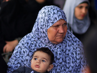 A Palestinian woman carries her baby as she hopes to cross into Egypt at the Rafah crossing between Egypt and the southern Gaza Strip April...