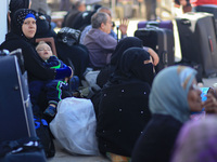 A Palestinian woman carries her baby as she hopes to cross into Egypt at the Rafah crossing between Egypt and the southern Gaza Strip April...