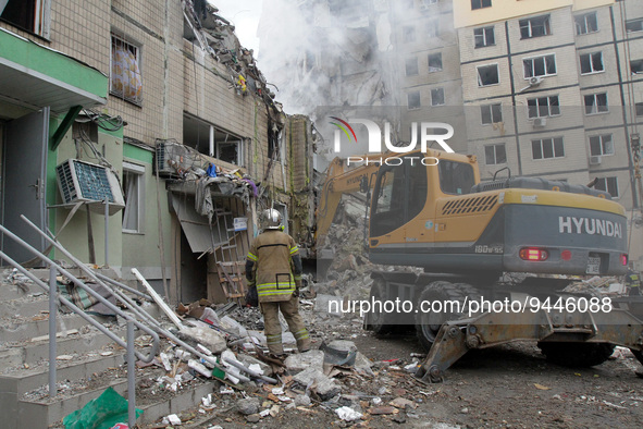 DNIPRO, UKRAINE - JANUARY 15, 2023 - A rescuer watches an excavator remove the rubble at an apartment block hit by a rocket launched by Russ...