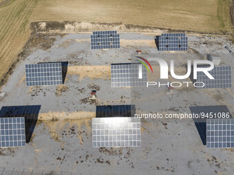 Aerial panoramic view from a drone of solar energy modules or panels rows along the hills of Drama region in Northern Greece with a larger p...