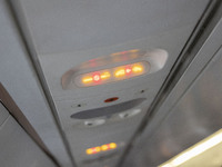 Cabin lights illuminated with fasten your seatbelt and no smoking signs while air vents are seen on the background. Inside the cabin of a Ye...