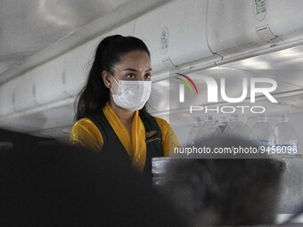 Flight attendant serving passengers during the flight. Inside the cabin of a Yeti Airlines ATR 72 propeller aircraft as seen on a flight fro...
