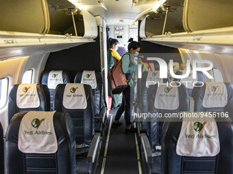 Yeti Airlines logo on the seats inside the cabin of a Yeti Airlines ATR 72 propeller aircraft and people disembarking as seen on a flight fr...