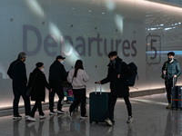 Passengers with luggages walk in Incheon International Airport on January 18, 2023, South Korea. According to Incheon International Airport...
