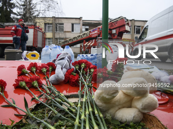 People leave Flowers and toys on a fragment of a helicopter that crashed near kindergarten,  in the Brovary town, in the outskirts of Kyiv,...